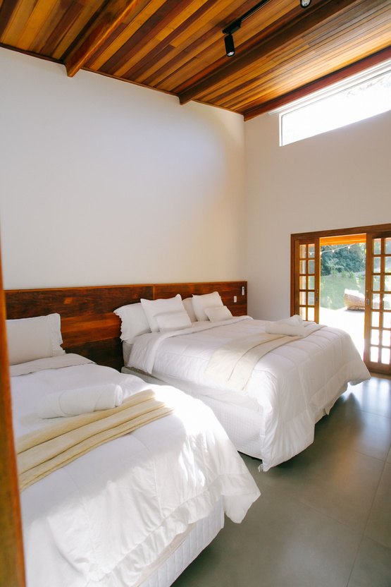 Suíte da Casa Lago com cama de casal e vista para o jardim