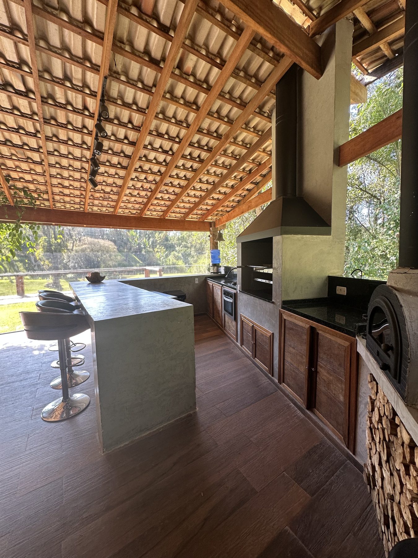 Cozinha gourmet da Casa Lago com balcão, churrasqueira e forno de pizza
