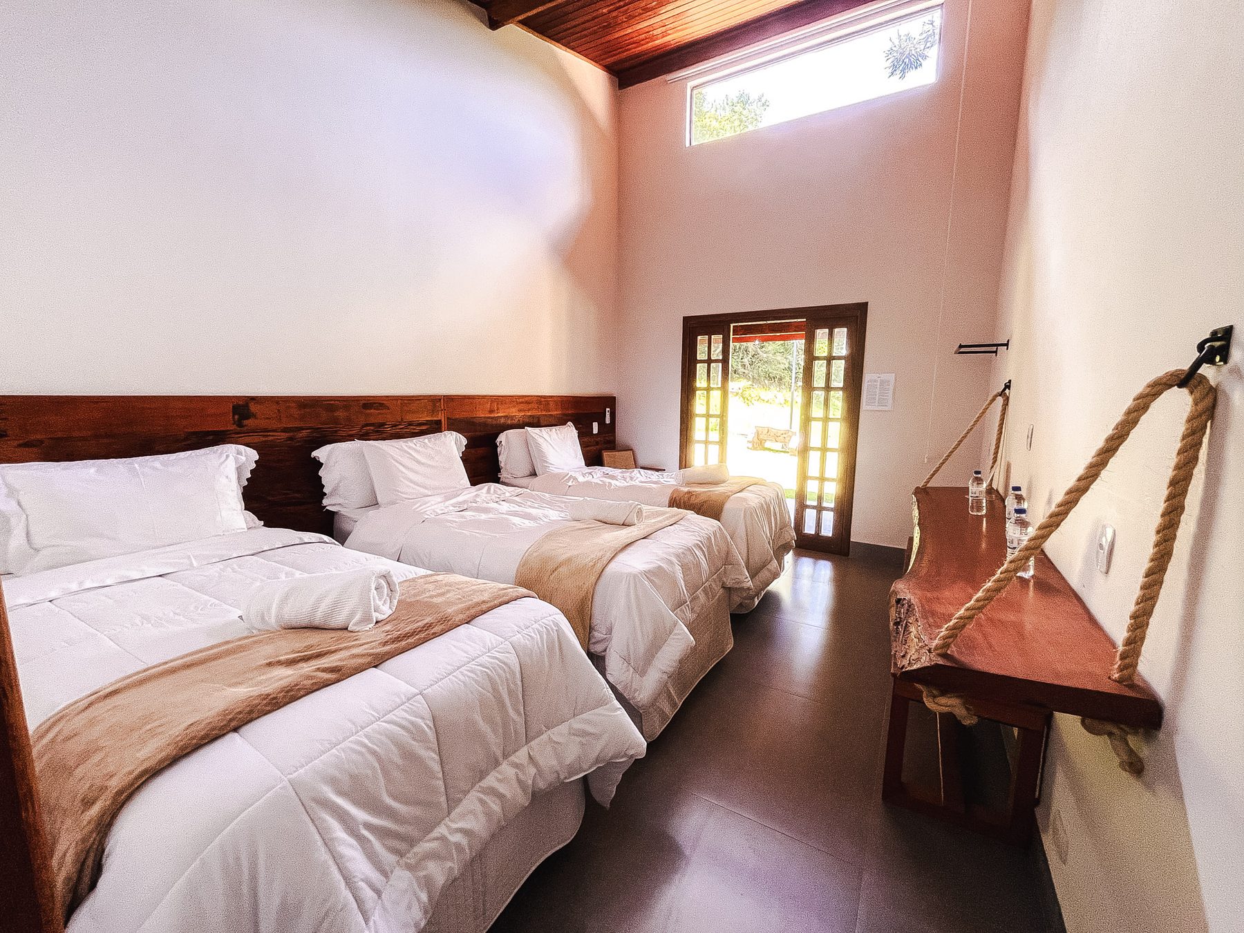 Quarto triplo com pé-direito alto e saída para a varanda
